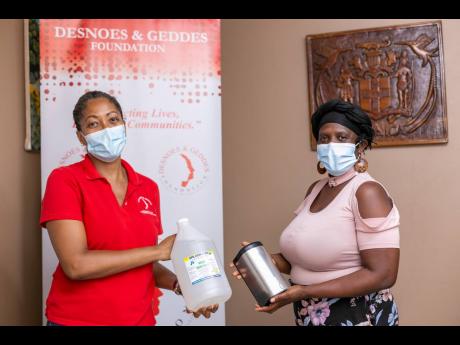 Stephannie Coy (left), project manager, Desnoes and Geddes Foundation, hands over sanitisation products to Angela Gordon-Black, principal of Callaloo Mews Basic School.  The  foundation recently donated approximately $200,000 worth of products to schools f