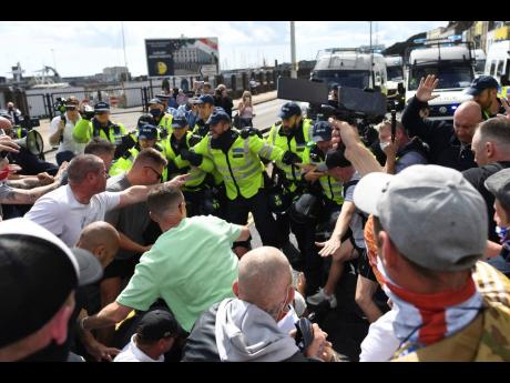 Anti-migrant protesters react with police in Dover, England, on Saturday. The protesters are calling for authorities to do more to protect English shores, at England’s southern port city nearest to mainland Europe. 