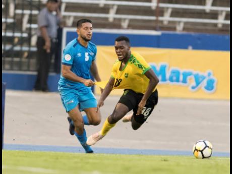 Jamaica’s Brian Brown (right) is taken down by Aruba’s Noah Harris during a Concacaf Nations League game at the National Stadium on Saturday, October 12, 2019.