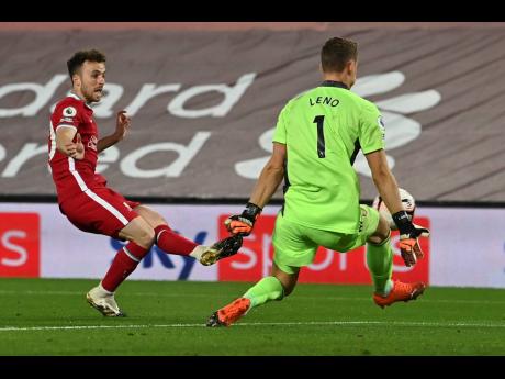 Liverpool’s Diogo Jota (left) takes a shot at goal as Arsenal goalkeeper Bernd Leno blocks during their English Premier League match at Anfield in Liverpool, England, yesterday.