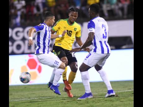 Jamaica’s Peter Vassell (centre) attempts to get between Honduran players Hector Castellanos (left) and Maynor Figueroa, during their Concacaf Gold Cup match held at the National Stadium on June 18, 2019. Jamaica won 3-2.