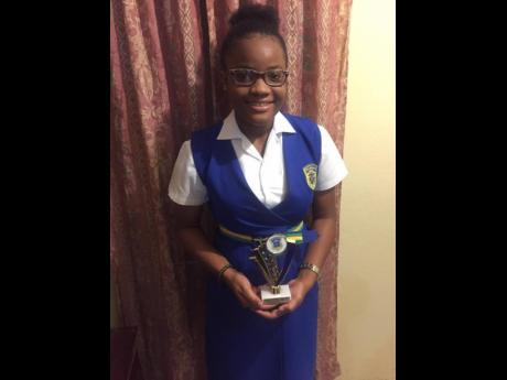 Kimona Barnes holds a smaller version of the Seymour Panton Award trophy which she received for her outstanding academic performance at Rusea’s High School in Hanover.     