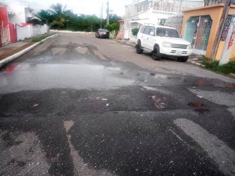 Credit: Photo by Ruddy Mathison Sewage spills on to a street in Waterford, St Catherine, on Tuesday. Residents of the Portmore community have complained about recurrent overflows during heavy showers.