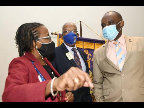 Jamaica Teachers’ Association President Jasford Gabriel (right) engages in conversation with Lions Denise Forrest (left) and Lion Errol Lee, past district governor, during yesterday’s monthly luncheon of the Lions Club of Kingston at The Jamaica Pegasu