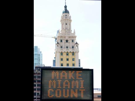 Credit: AP A flashing sign reads, “Make Miami Count,” near the iconic Freedom Tower on Monday, October 5, in downtown Miami.