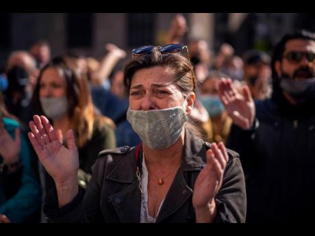 Credit: The Associated Press A woman cries during a protest organised by restaurant and bar owners in Barcelona, Spain, yesterday. Authorities in northeastern Spain ordered all bars and restaurants closed for two weeks.