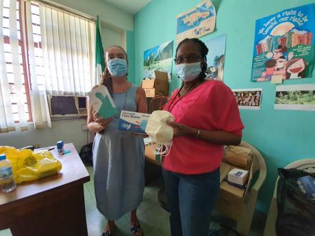Carla Gullotta, executive director of Stand Up For Jamaica, hands over 17,000 face masks and nine thermal scanners to Winsome Harris, director of public procurement at the Department of Correctional Services. 