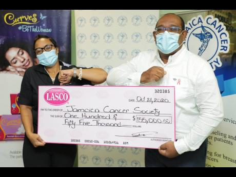 Tameka Singh-Kellier (left), brand manager at LASCO Distributors Limited, presents a Curves donation of$150,000 to Jamaica Cancer Society’s (JCS) Michael Leslie, acting executive director and finance manager, on Wednesday at the JCS’s office in Kingsto