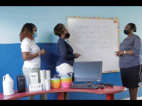 General Accident Insurance Company’s Colesha Mahoney (left) and Kerry-Ann Spencer (centre) present Maisie Green Learning Centre Principal Charmaine Bennett with the computer and other items donated to the school recently.