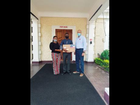 Credit: Contributed Kashief Barton (centre), recipient of the 2020 Spirit of ‘86 scholarship; his mother, Matenta Simms; and Colonel Ogilvie.