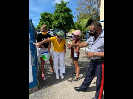 From left: Outgoing Canadian High Commissioner Laurie Peters; incoming EU Ambassador Marianne Van Steen; Thalia Lyn, CEO of Island Grill; and Sergeant Hanna of the Oracabessa Police Station participate in the painting of  the Oracabessa Police Station over