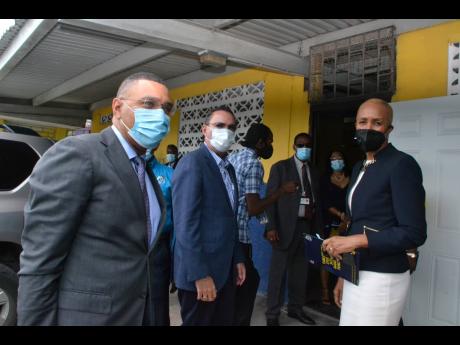 Prime Minister Andrew Holness (left) is greeted by Education Minister Fayval Williams on arrival at Drews Avenue Primary and Infant School in his St Andrew West Central constituency on Wednesday. The occasion was marked by the handover of tablets to studen