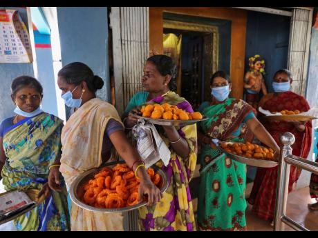 Credit: AP Women carry large plates filled with traditional sweets to be distributed among villagers, after special prayers, to celebrate the victory of US Vice-President-elect Kamala Harris at a Hindu temple in Thulasendrapuram, the hometown of Harris’ maternal gr