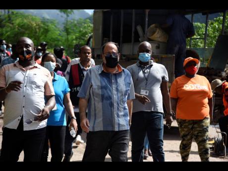 Credit: Nicholas Nunes/Photographer Dayton Campbell (left) accompanies Opposition Leader Mark Golding Thursday on a tour of Stand Up Hill along the Gordon Town main road, which has been hit by land slippage caused by persistent rain.