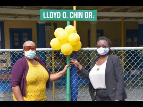 Acting principal of Titchfield High School  Sheryl Horne-Mair (right) and board member Elaine Williams beside the newly erected sign for Lloyd O. Chin Drive on the institution’s campus, following the ribbon-cutting ceremony on November 11. 