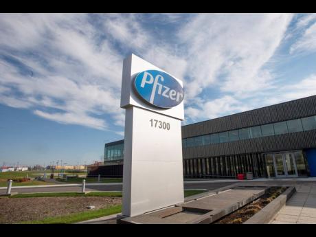 A sign with the Pfizer logo stands outside the corporate headquarters of Pfizer Canada in Montreal, on Monday, November 9, 2020.