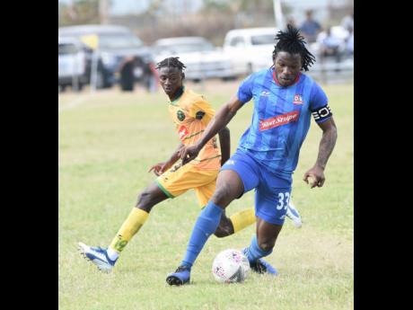 Rickardo Messam (left) from Vere United was decieved into  going the wrong way by Shaquille Dyer (right) from Dunbeholden United their National Premier League match which was played at the Wembley Centre of Excellence in Vere, Clarendon on Sunday, February