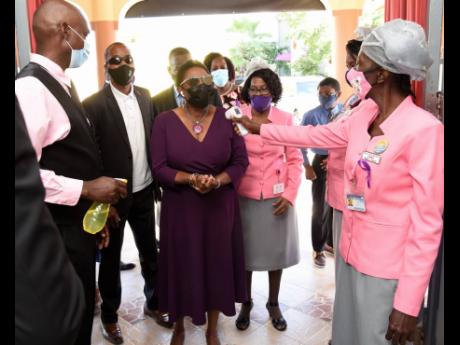 Olivia Grange, minister of gender affairs, has her temperature read and hands sanitised by members of Power of Faith Ministries in Portmore, St Catherine, before she entered the church. Sunday’s church service kicked off commemoration of International Da