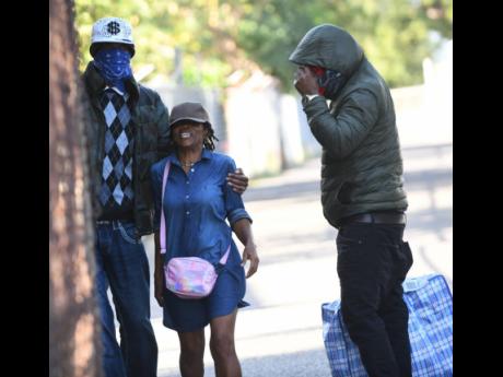 A deportee, with face covered, is met by a relative at Harman Barracks in Kingston in February. Dozens of Jamaicans are expected to arrive from Britain today. 