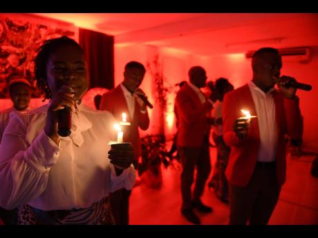 Illumuinated by candlelight, Ashe’s Ackeria Smith and Khumar McHugh are front and centre as they perform on World AIDS Day.