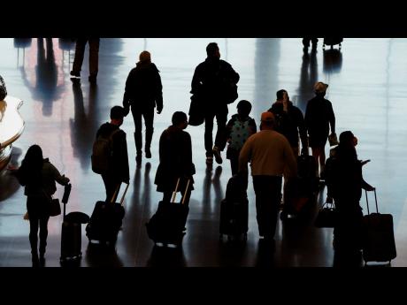 Credit: AP FILE - In this Wednesday, November 25, 2020 file photo, travellers walk through the Salt Lake City International Airport in Salt Lake City, a day before Thanksgiving.