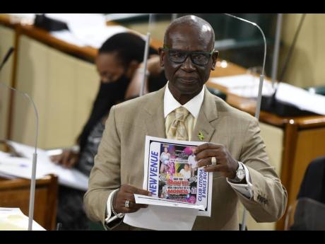 Minister of Local Government and Rural Development Desmond McKenzie holds a flyer promoting a December 9 event at Club Utopia in Bull Bay, St Andrew, in breach of the Disaster Risk Management Act. 
