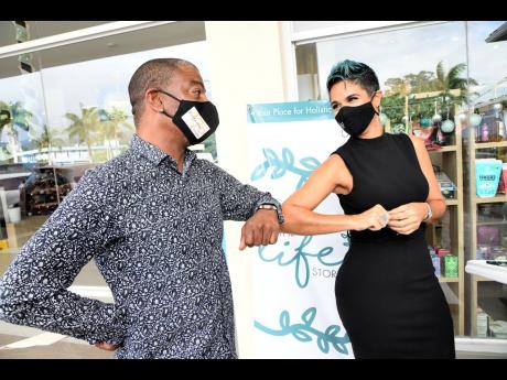 Elbow bumps are the new handshake. Natalie Murray greets Rodney Campbell at the launch of her wellness boutique. 