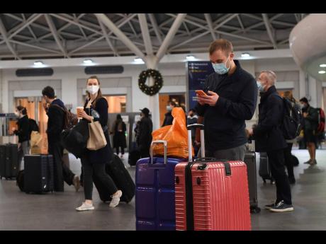Credit: AP Travellers wait for trains on the concourse at King’s Cross station in central London, Sunday, December 20, 2020. Millions of people in England have learned they must cancel their Christmas get-togethers and holiday shopping trips. British Prime Minister