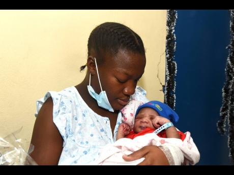 First-time mom Naketa Dockery cradles her newborn Leondre Gray. Leondre was born at 3:34 a.m. on Christmas Day at the Victoria Jubilee Hospital, weighing 3.48kg. The mother received a basket and other supplies from the Kiwanis Club in collaboration with An