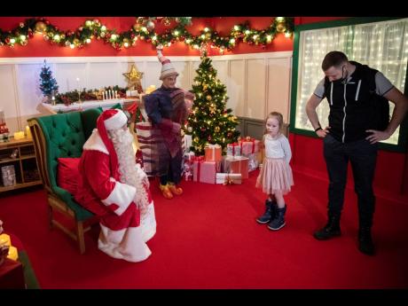Credit: AP Ded Moroz (Santa Claus, or Father Frost) speaks to a girl, in the amusement park Dream Island in Moscow, Russia, yesterday. While Europe is mainly in lockdown over the Christmas holidays, Russians continue to celebrate, with offices parties and festivities