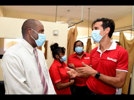 Burknell Stewart (left), CEO of Kingston Public Hospital and Victoria Jubilee Hospital (VJH), raps with Michael Subratie, managing director of T. Geddes Grant, at the opening ceremony of the new breastfeeding room that was opened at the VJH on December 23.