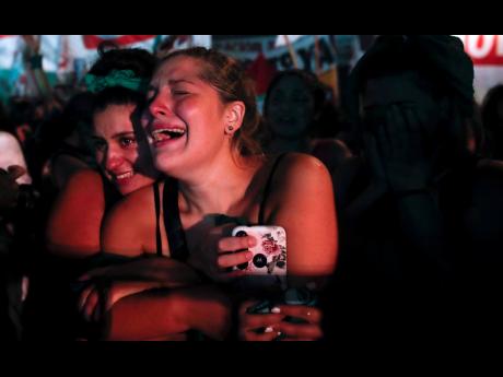 Abortion-rights activists react  outside the Congress in Buenos Aires, Argentina,  after lawmakers approved a bill that legalises abortion on Wednesday.  AP