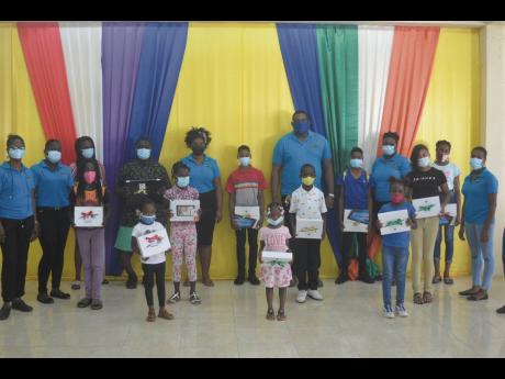 Rochelle Cawley (back row, fifth left), president of the Salt Spring Community Outreach Empowerment (SSCOPE) organisation’s Jamaica chapter, in a group shot with some of her group members and young recipients of electronic devices at the Salt Spring Peac