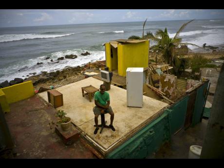 This October 5, 2017 file photo shows Roberto Figueroa Caballero sitting on a small table in his home that was destroyed by Hurricane Maria in the La Perla neighbourhood on the coast of San Juan, Puerto Rico. The hurricane impacted a number of Caribbean is