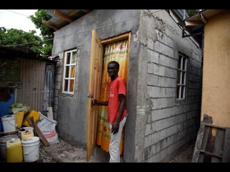 Nigel Townsend stands in the doorway of his recently completed house in the Fitzgerald Avenue community off Maxfield Avenue in St Andrew. Good Samaritans rallied to construct a new home for him after The Gleaner highlighted his living situation in a collap