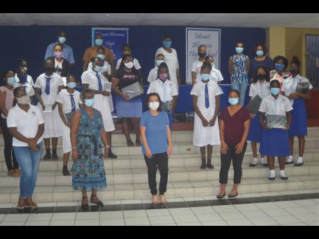 Credit: Contributed Dawn Chin-Jones (front, centre), president of the Mt Alvernia High School Central Florida Alumni Association, and members of the school’s staff and her alumni group, pose for the camera with some of the students who were presented with laptops and tablet