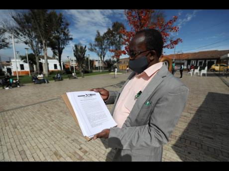 Community leader Baldoino Asprilla shows a death threat that was sent to him, during an interview in Bogota, Colombia, Thursday, December 17, 2020. Last year, 120 community leaders were murdered in Colombia according to the UN hHigh commissioner for human 