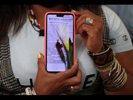 Community leader Luz Nelly Santana shows one of the many death threats she has received, during ann interview in Bogota, Colombia, Thursday, December 17, 2020. The Afro-Colombian community leader sometimes uses a hat or a turban to disguise herself, and al