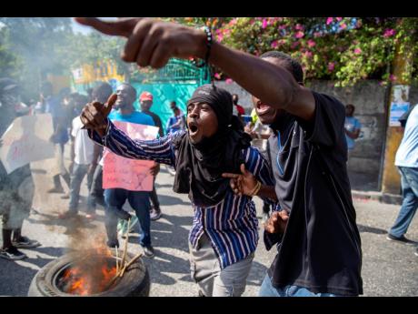 In this December, 2020 file photo, protesters chant anti-government slogans during a protest demanding the release of political prisoners and the resignation of Haitian President Jovenel Moise in Port-au-Prince, Haiti. Haiti is bracing for a fresh round of