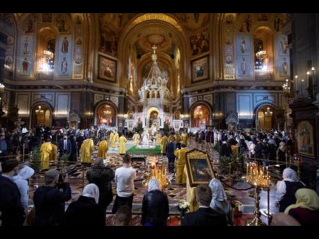 Russian Orthodox Patriarch Kirill, center, delivers the Christmas Mass in the Christ the Saviour Cathedral in Moscow, Russia, late Wednesday, January 6, 2021. Parishioners wearing face masks to protect against coronavirus, observed social distancing guidel