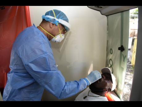 Dr M Wilder does a COVID-19 test on Livinston Johnson in Yallahs St Thomas on Saturday January 16,  as part of the Health Departments effort to provide free testing. The exercise was met with a lukewarm response with many residents choosing not to be teste