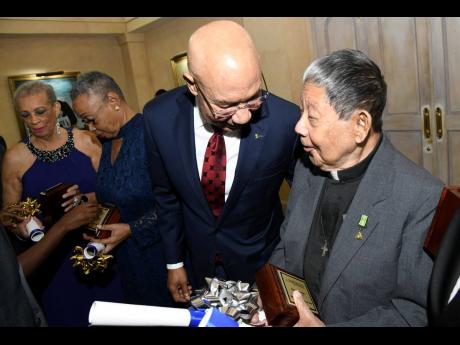 Governor General Sir Patrick Allen (left) speaks with awardee Reverend Easton Lee at the National Chorale of Jamaica Medal of Excellence Awards ceremony at King’s House in St Andrew on May 5, 2019.