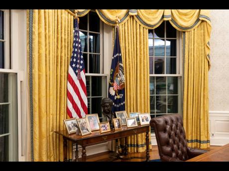 The desk behind President Joe Biden is filled with an array of framed family photos.