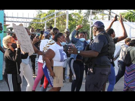 Credit: Nathaniel Stewart/Photographer Residents of Rocky Point, Clarendon, protest on Tuesday the detention of Nicholas Graham. The businessman has been in police custody since Sunday afternoon.