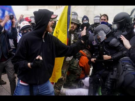 Credit: AP In this January 6 photo, Trump supporters try to break through a police barrier at the Capitol in Washington. In dozens of cases on social media,Trump supporters downright flaunted their activity on the day of the deadly insurrection. Some, apparently real