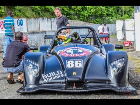 Veteran racer David Summerbell looks on as Bajan racer Mark Maloney gets last-minute instructions from his crew.