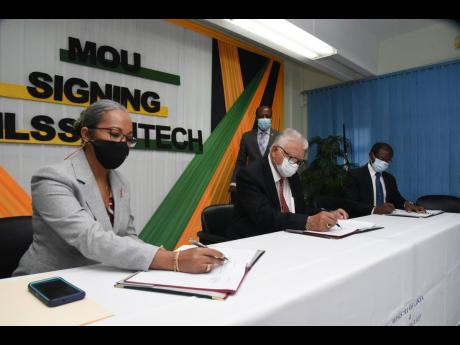 Labour and Social Security Minister Karl Samuda (second left) signs a memorandum of understanding alongside Permanent Secretary Colette Roberts Risden. The two have been reported to have an icy relationship because of a number of internal squabbles. 