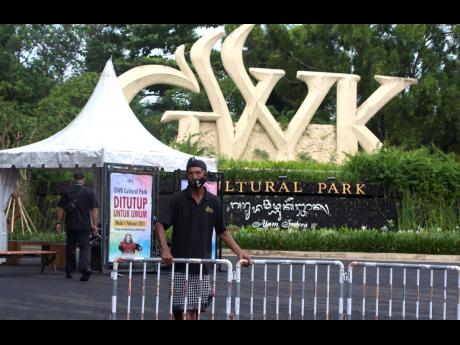 A Balinese traditional security guard, called ‘pecalang’, stands at an entrance of a cultural park which is temporary closed to the public in Bali, Indonesia, on Wednesday, February 3. Amid fears of new variants of the virus, new restrictions on moveme