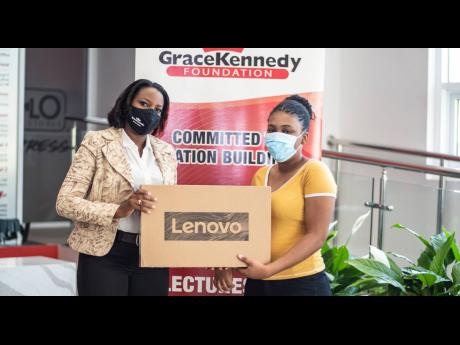 Terry-Ann Graver (left), director, GraceKennedy Foundation (GKF), presents a Lenovo laptop to Tashna-Gail Williams. A GK Foundation Merit Scholar, Tashna-Gail attends The University of the West Indies and is one of seven tertiary students who benefited fro