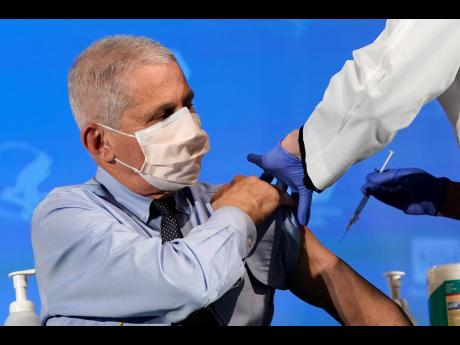  In this December 22, 2020 file photo, Dr Anthony Fauci, director of the National Institute of Allergy and Infectious Diseases, prepares to receive his first dose of the COVID-19 vaccine at the National Institutes of Health in Bethesda, Md. Fauci won a $1 